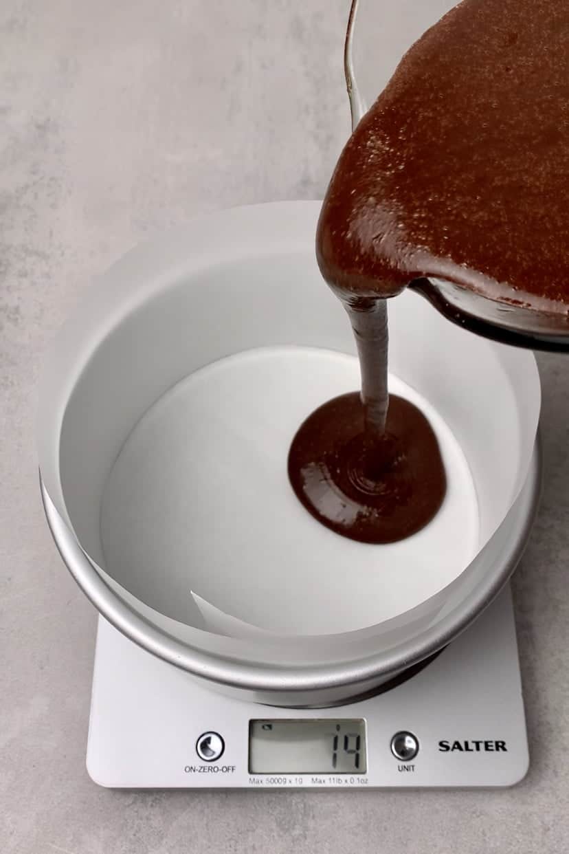 Pouring the chocolate sponge mixture into a baking pan .