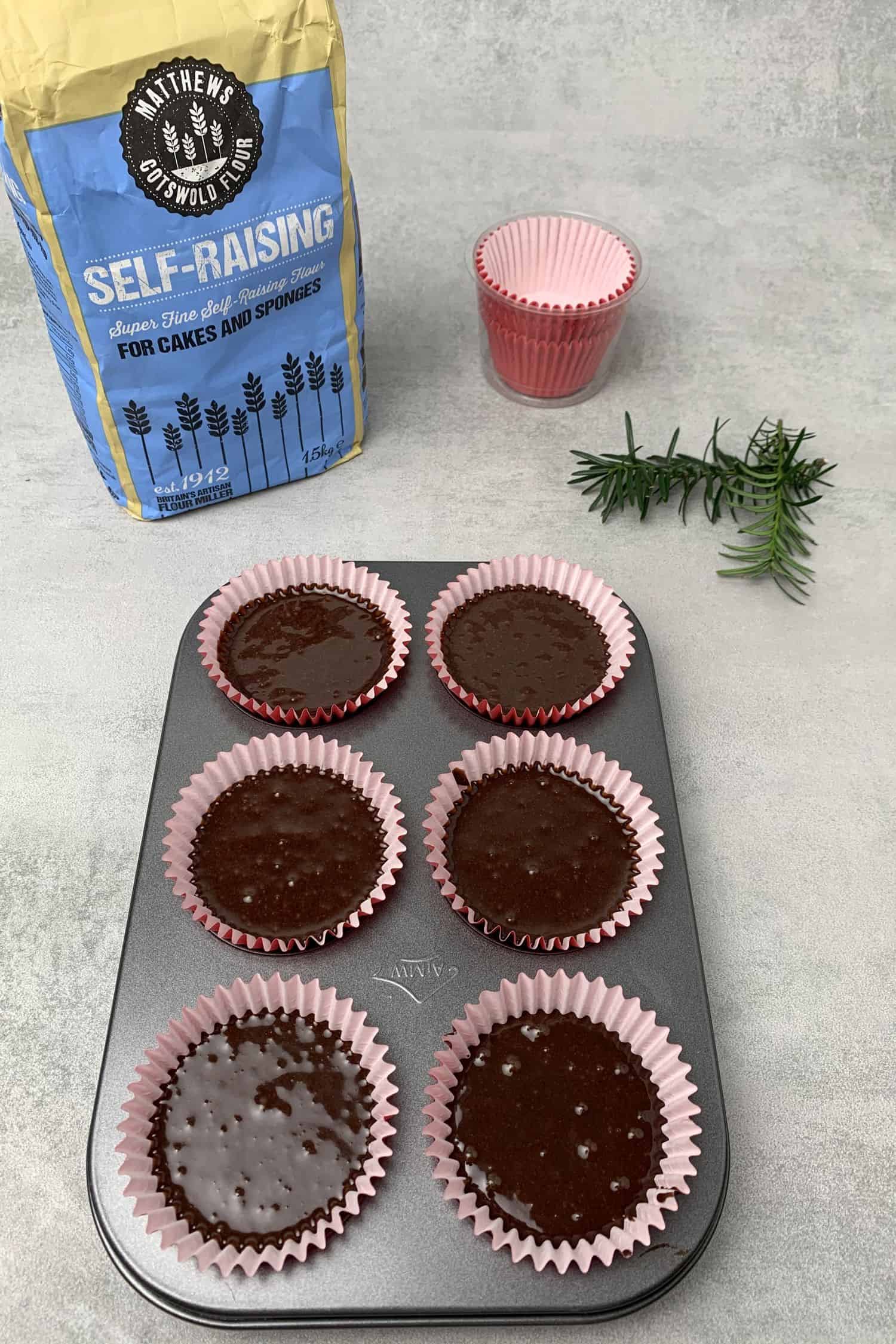Christmas tree cupcakes in a cupcake tin before baking.