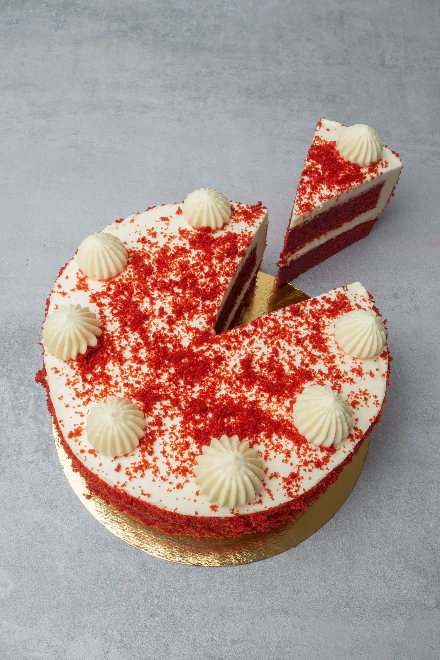 Red velvet cake from above on a golden paper plate.