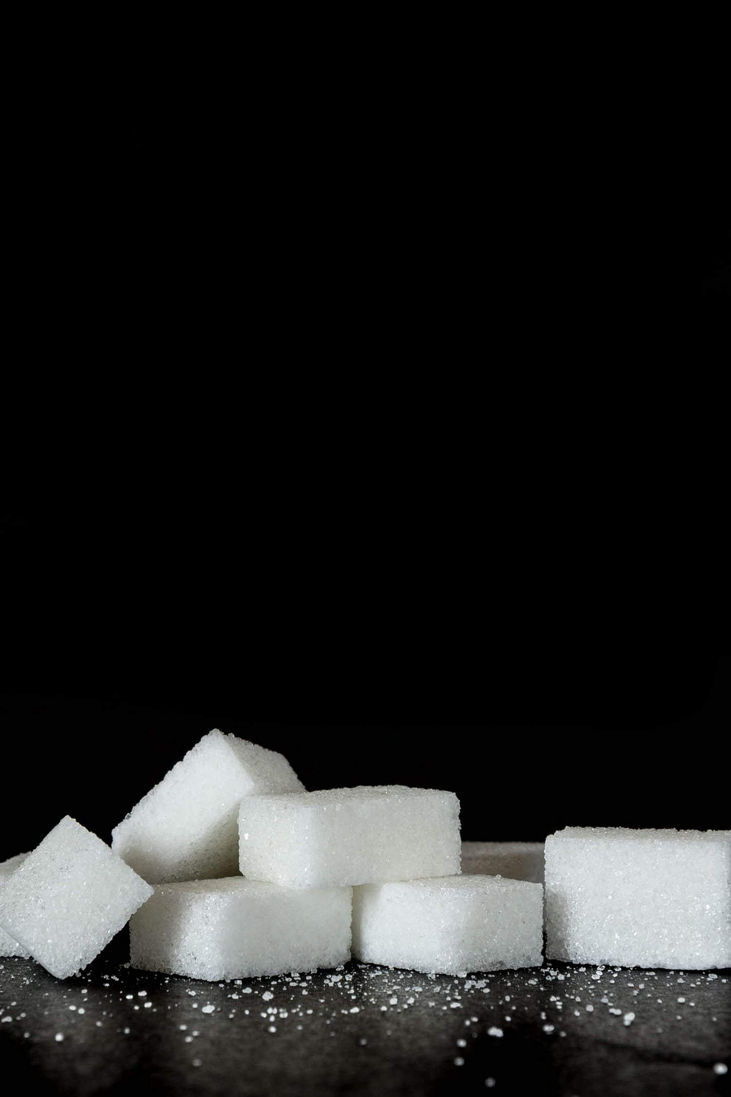 Sugar cubes in front of a black background.