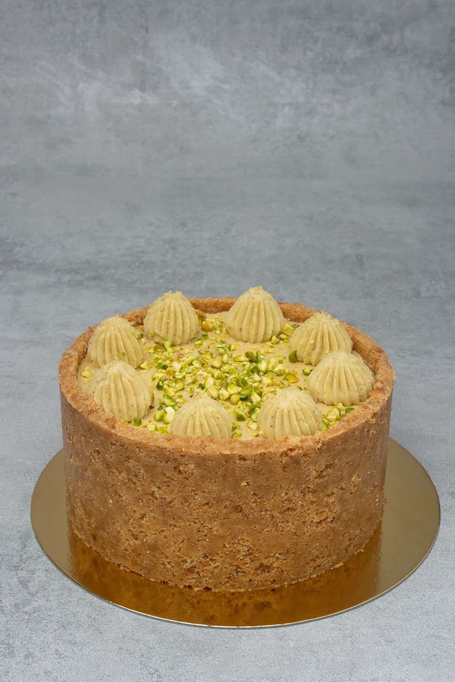 Pistachio cheesecake on a gold paper plate.