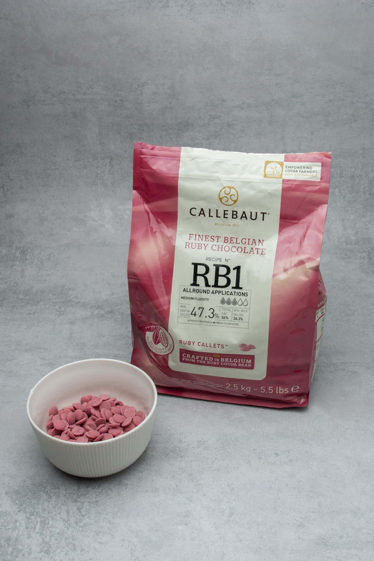 A bag of Callebaut ruby chocolate on a grey table top.