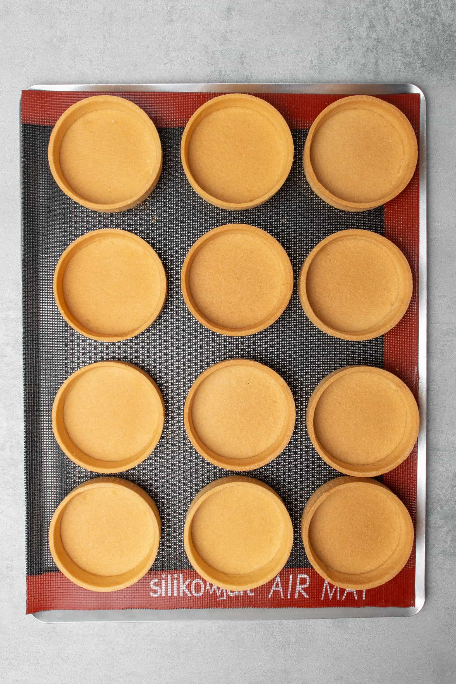 Pâte Sablée tart shells on a cooling rack.