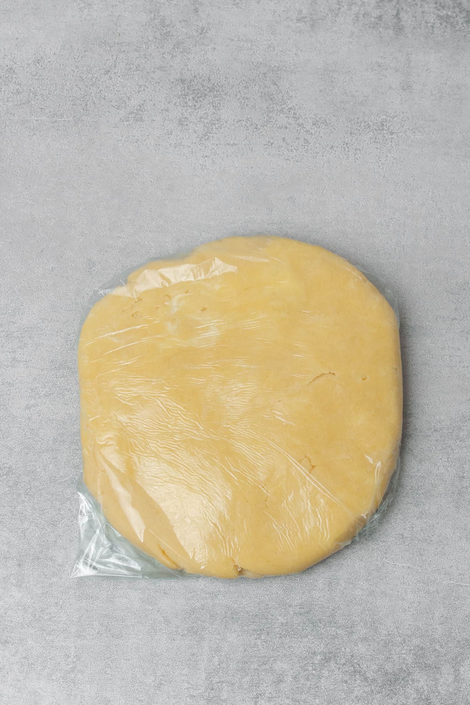 Galette dough wrapped with plastic foil.