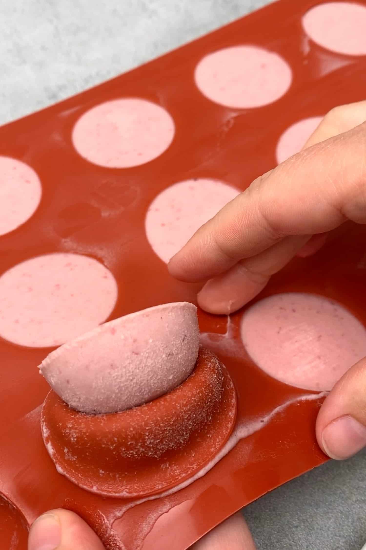 Removing the frozen chocolate based raspberry mousse from a silicone mold.
