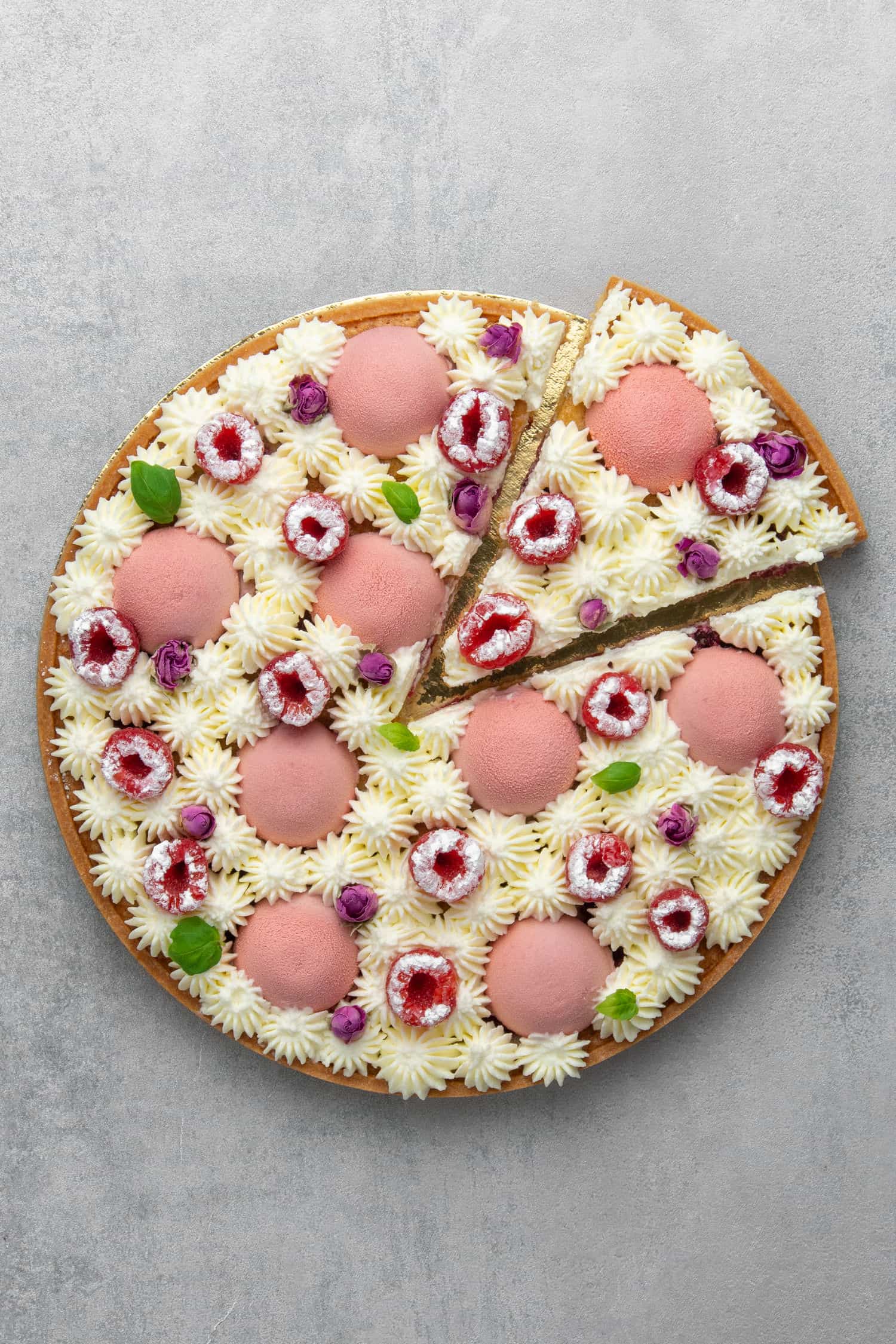 Raspberry Frangipane tart from top and a slice cut out. 