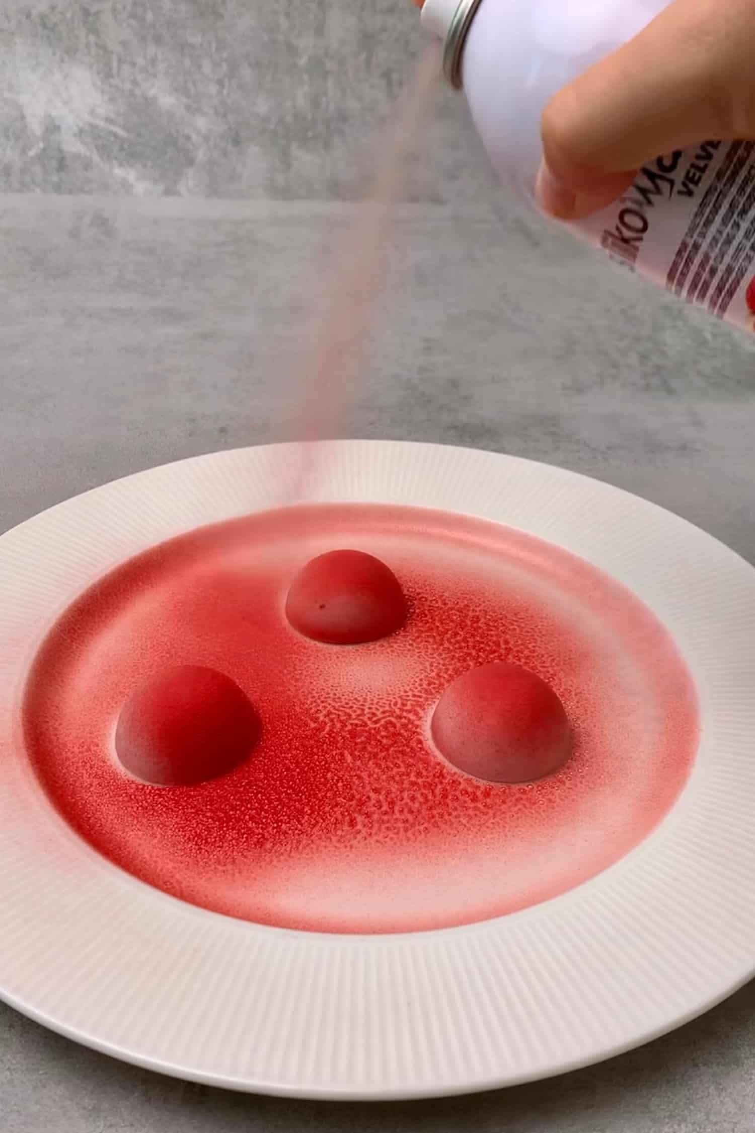 Spray velvet cream on the frozen raspberry mousse. 