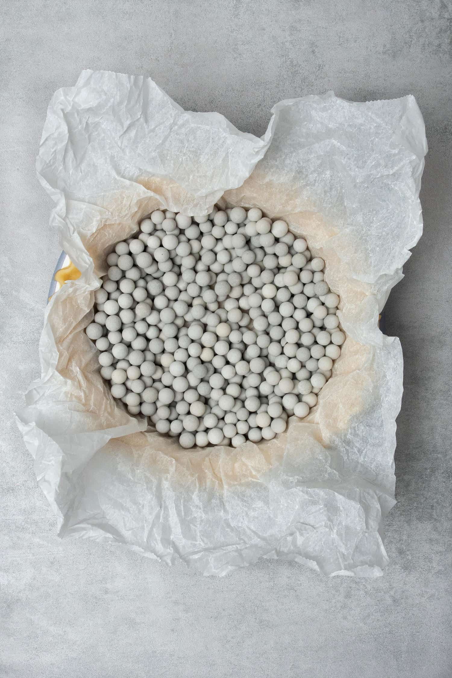 Pie dough filled with ceramic baking beans for blind baking