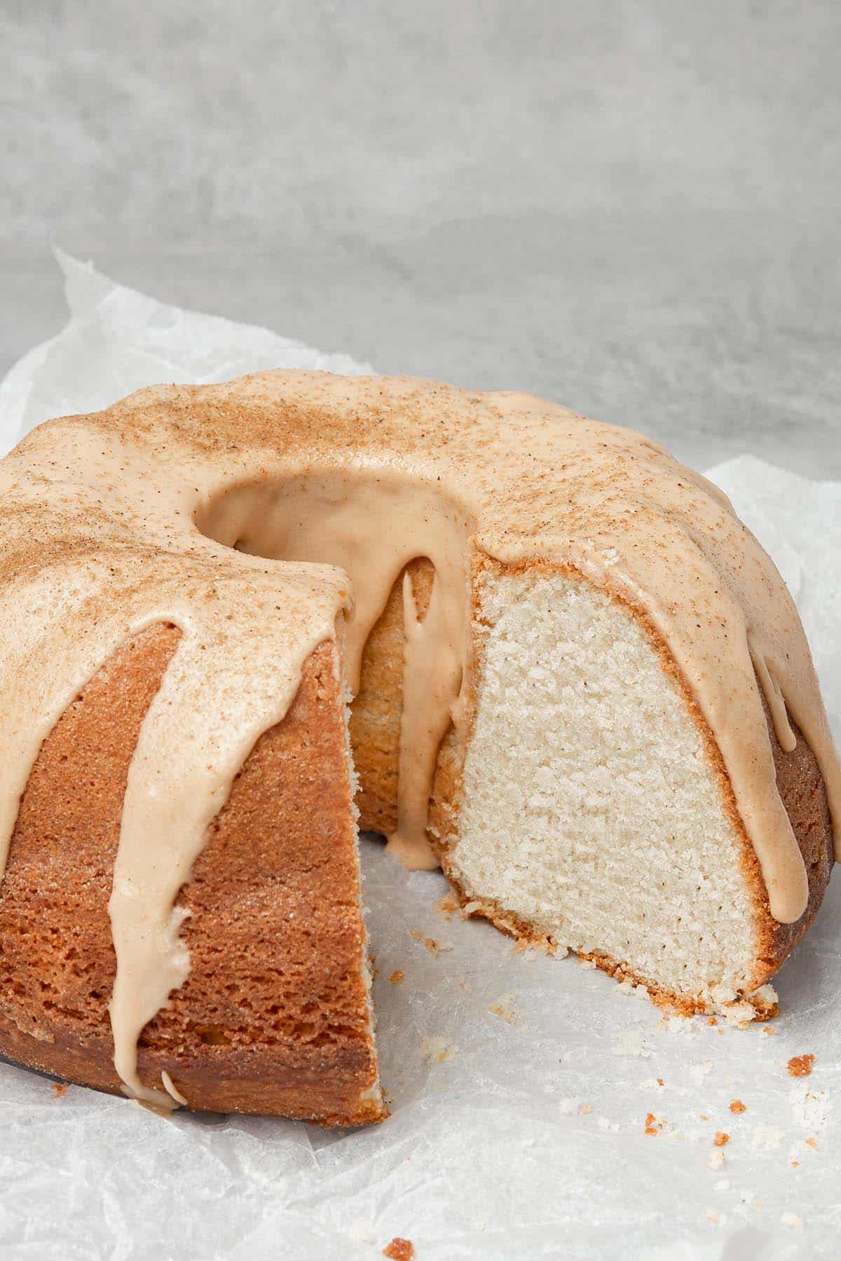 Cardamom cake with a cut  on a white baking paper