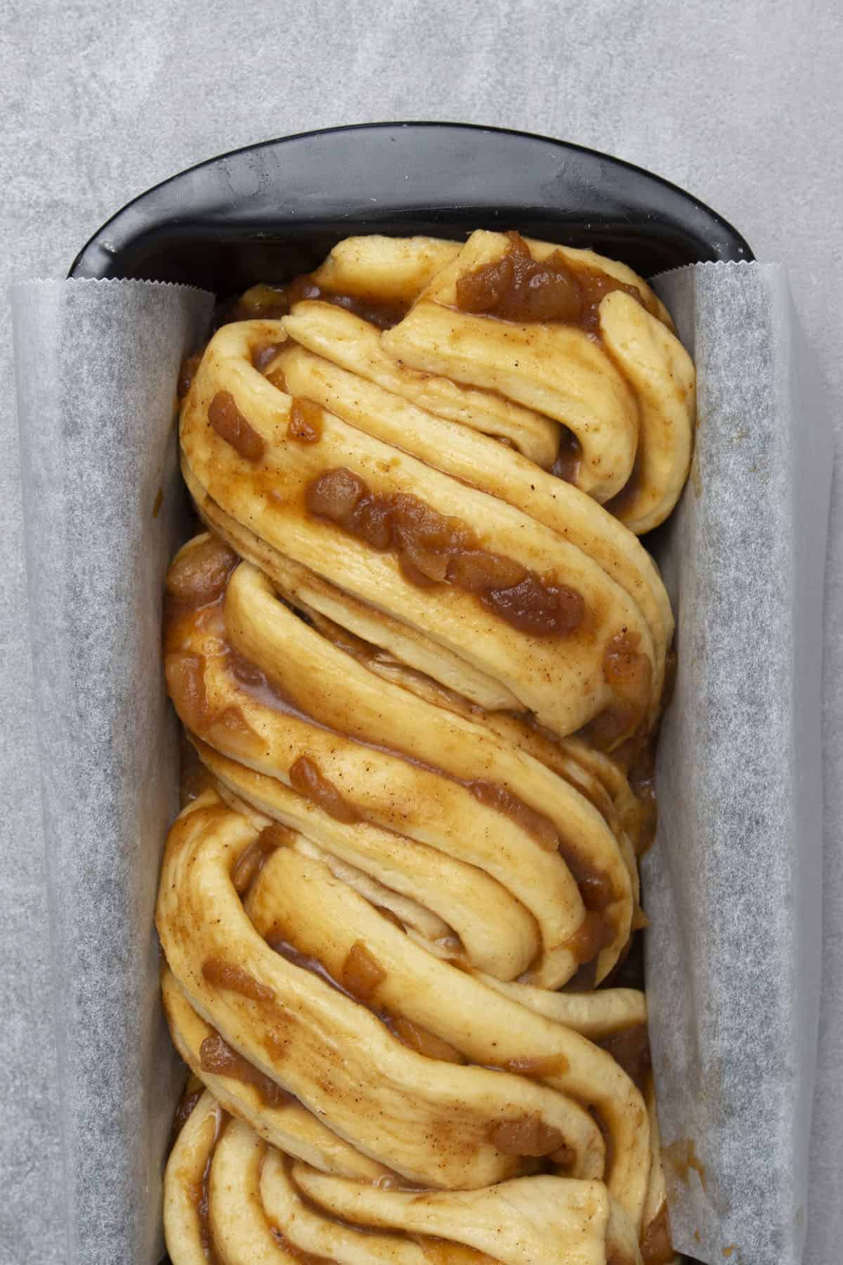 Cinnamon apple babka in a baking pan before baking.