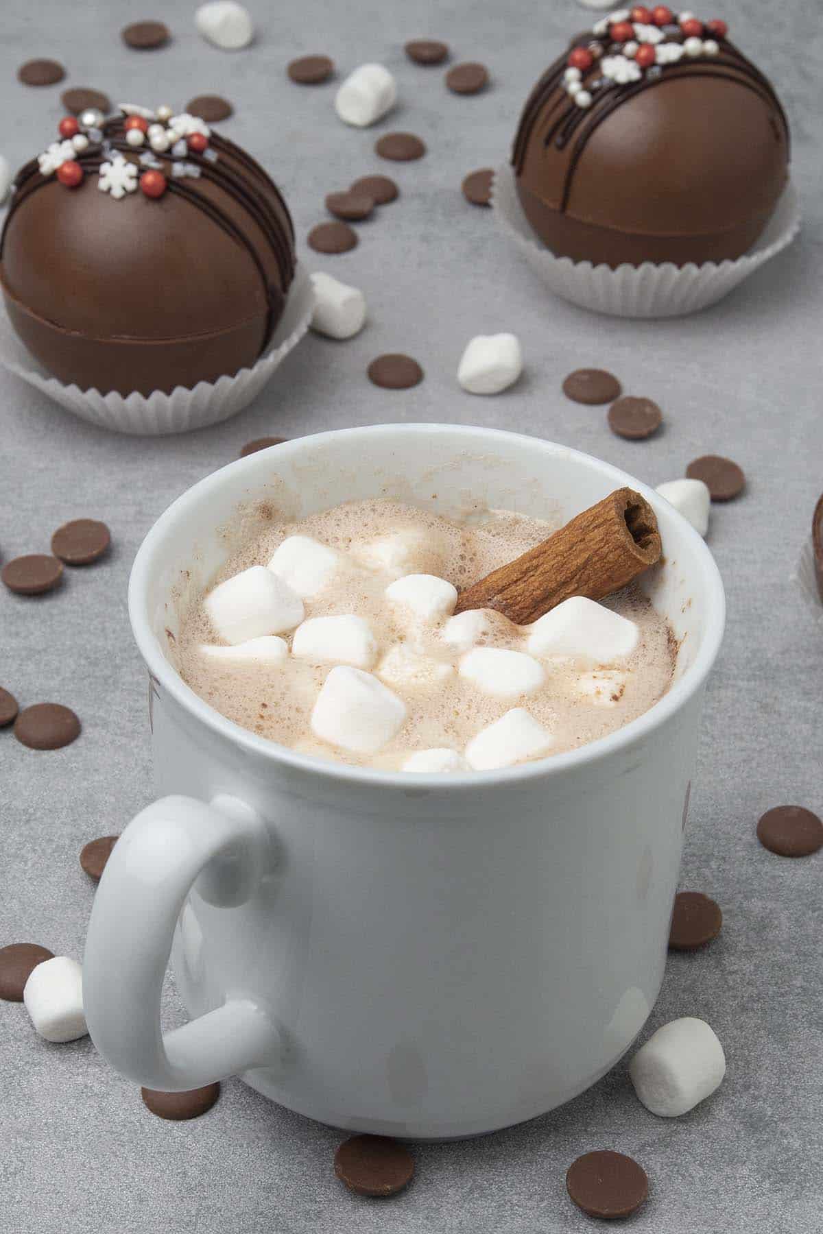 Hot chocolate bomb with cinnamon stick in a cup. 