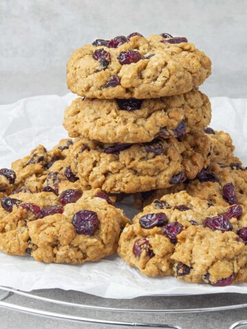 Oatmeal craisin cookies on top of each other on a cooling rack