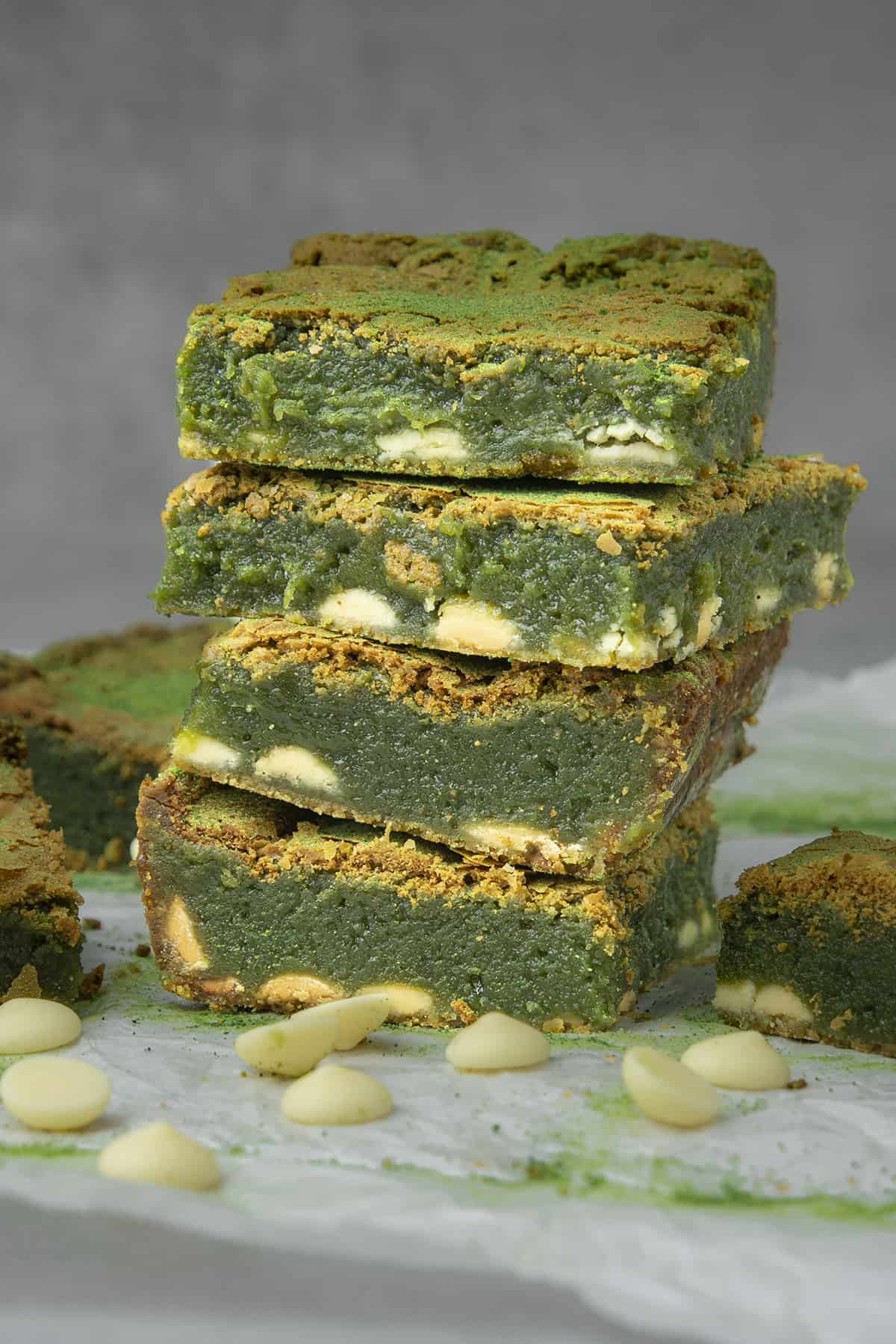 Four Matcha brownies on top of each others surrounded with white chocolate decoration 