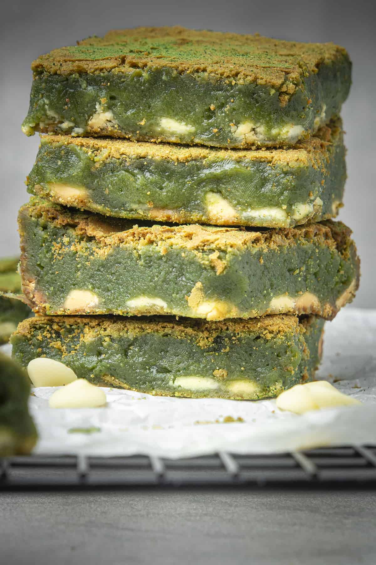Four slices of Matcha brownies on top of each other with a white background