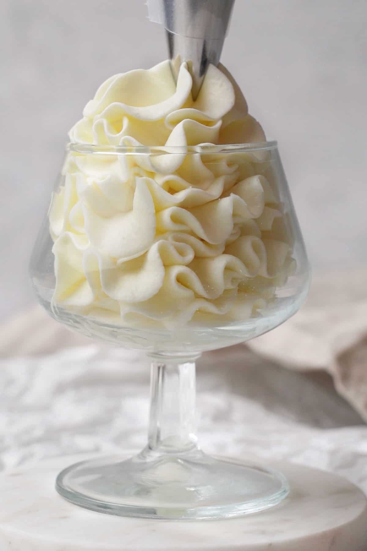cream cheese frosting piping into a glass.