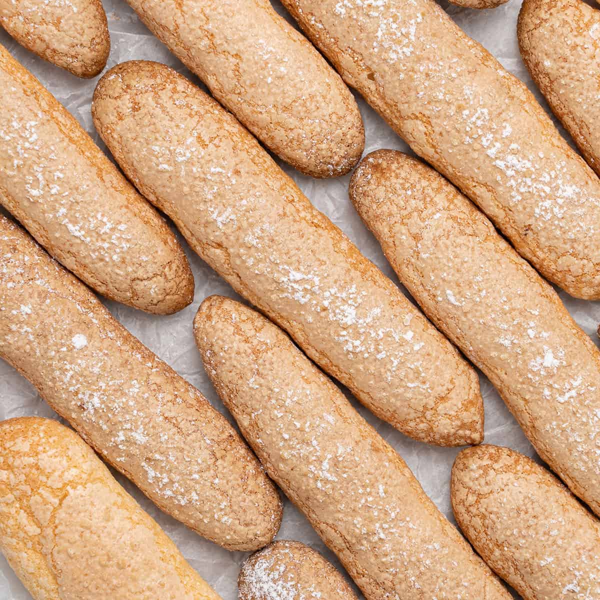 Ladyfingers side by side on a baking paper.