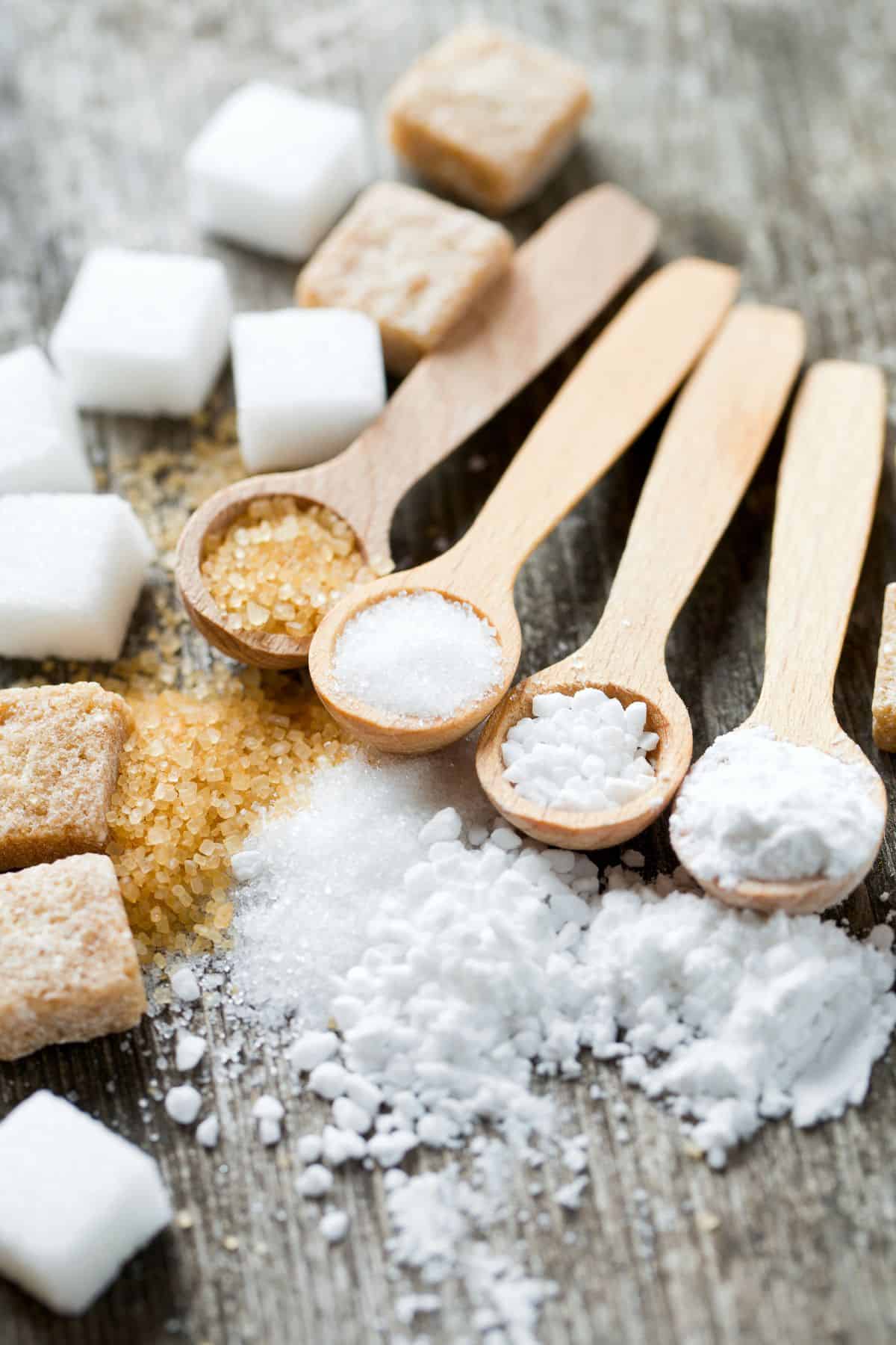 4 Different type of sugar in wooden spoons.