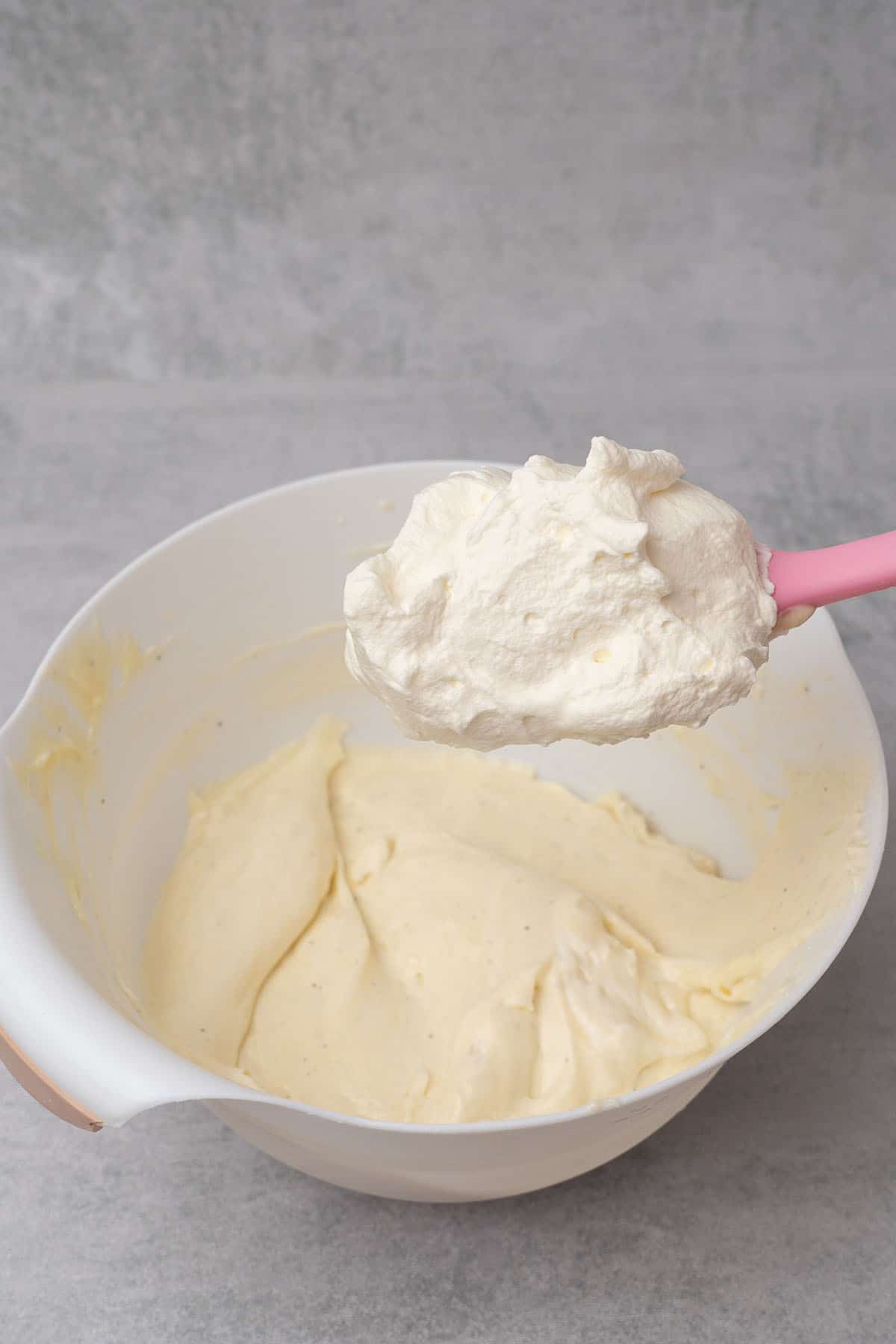 Mixing the pastry cream and whipped cream to make diplomat cream.