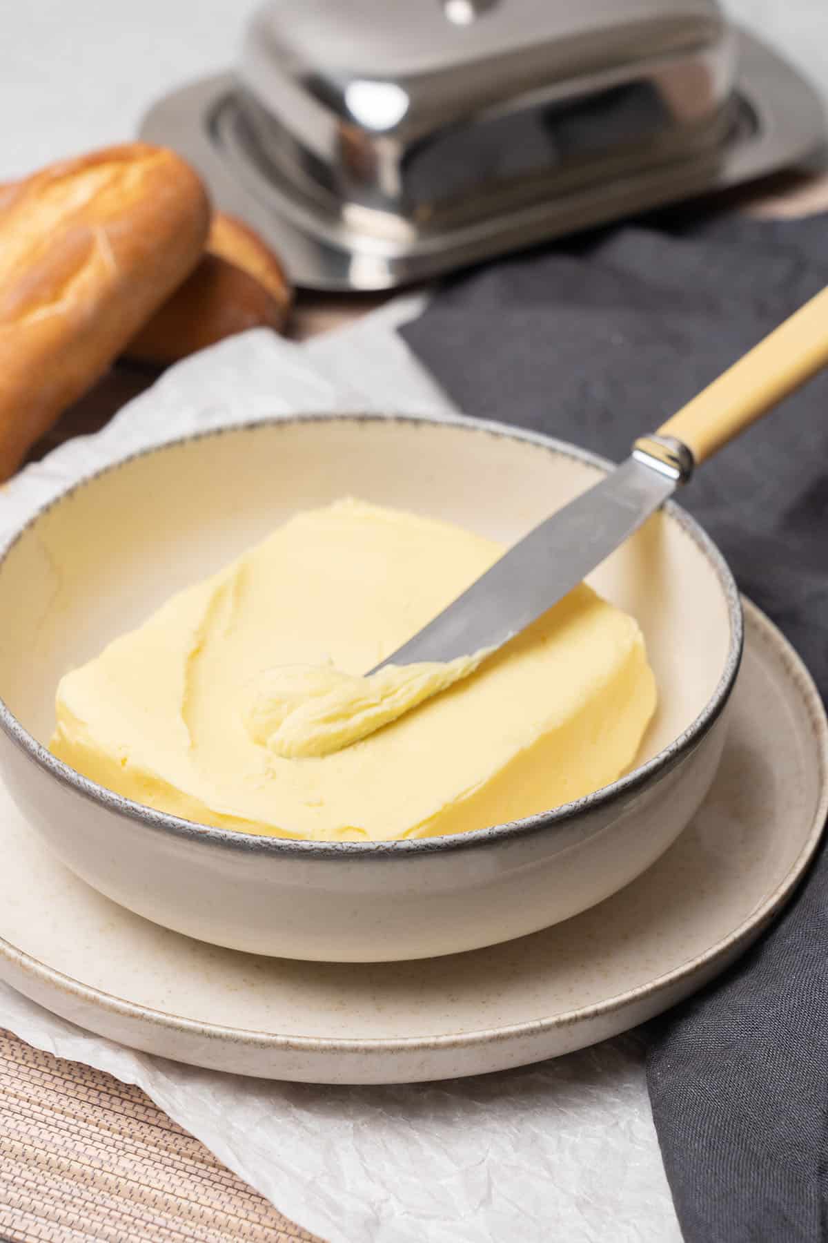 Homemade butter in a plate with a knife.