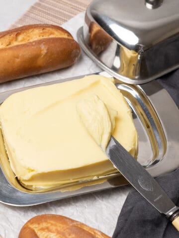 Homemade butter on a plate with a knife.
