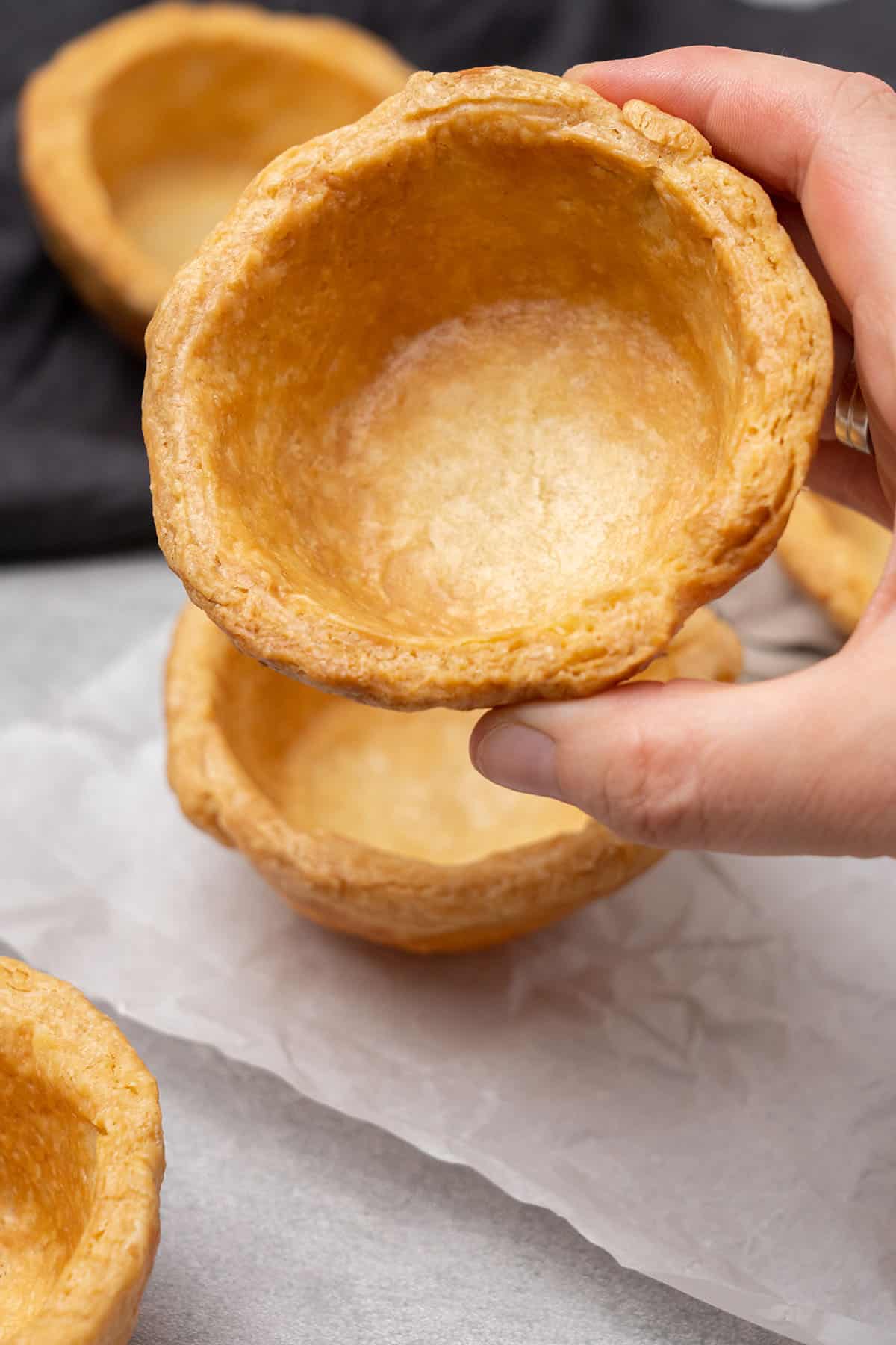 a hand holding a Mini pie crust.