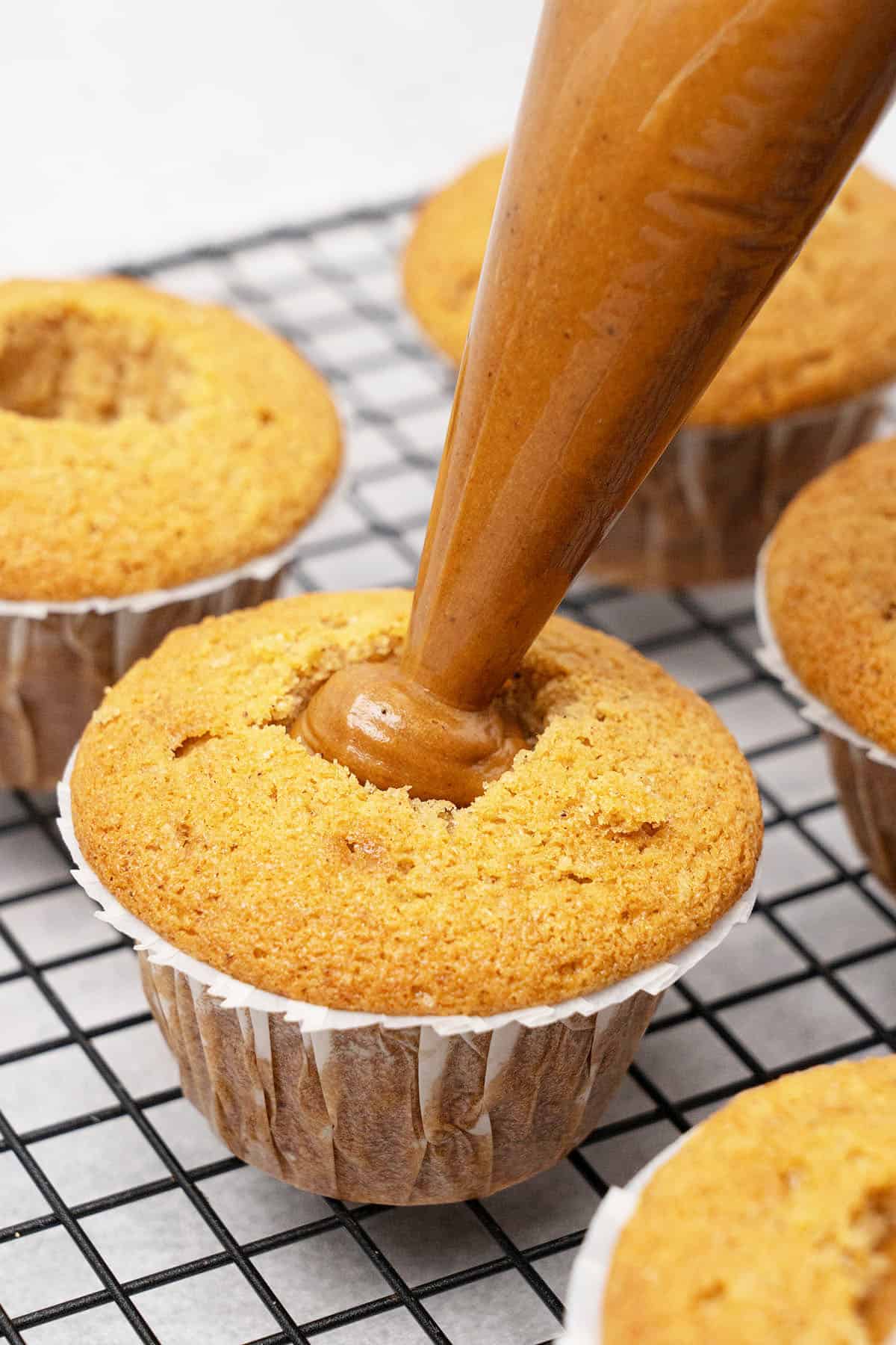 filling a cupcake with Biscoff spread.
