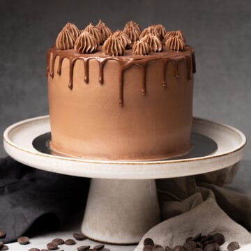 Triple chocolate cake on a cake stand.