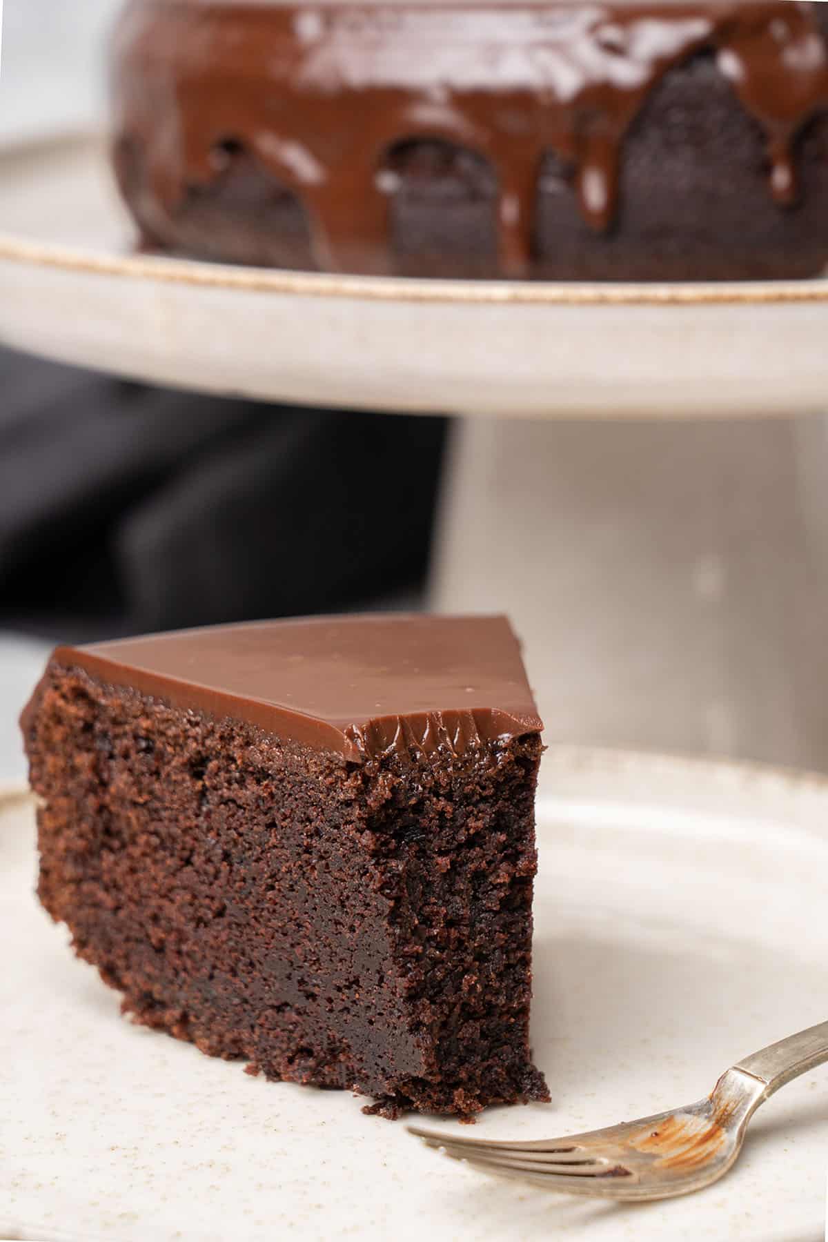 a slice of chocolate ganache cake on a plate.
