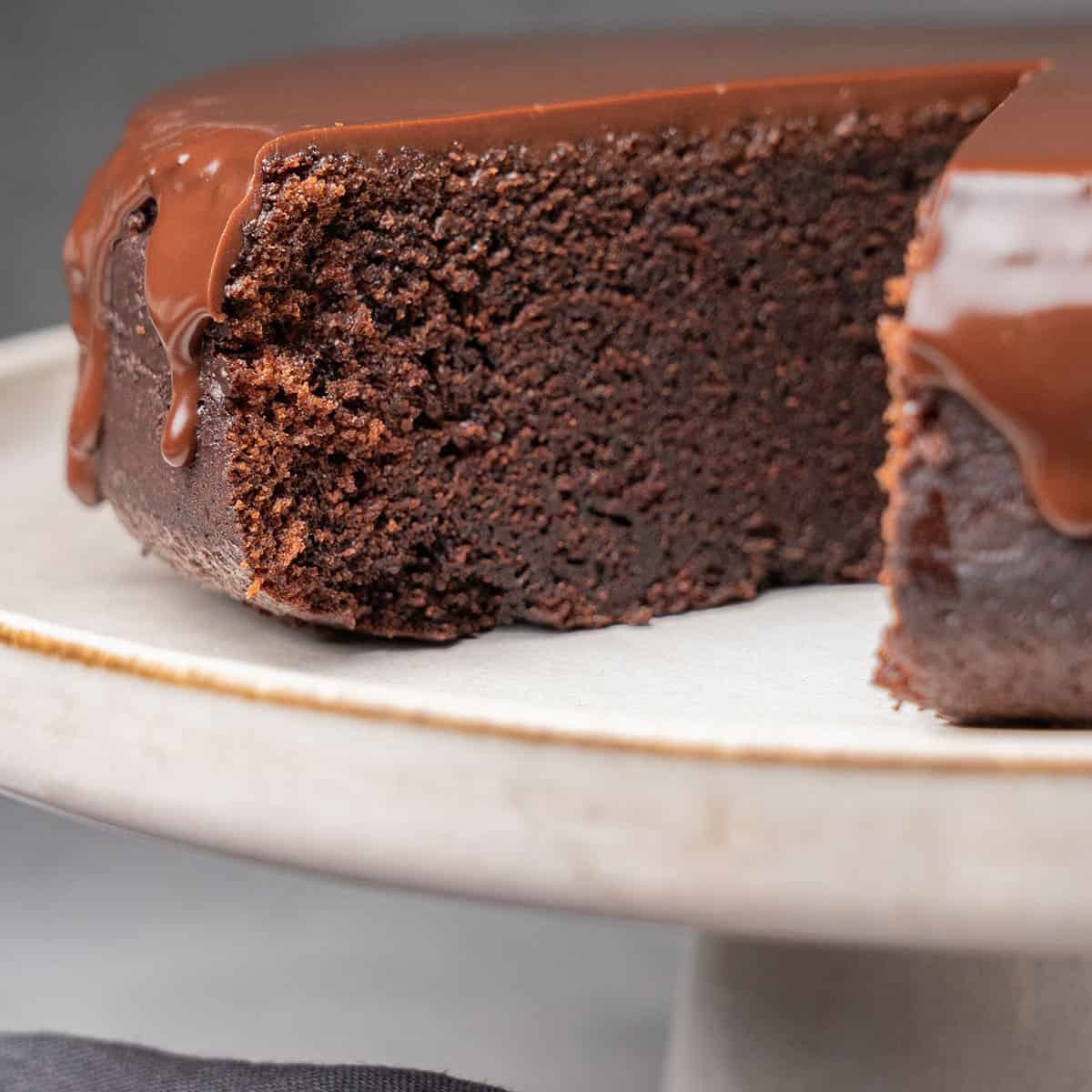 chocolate ganache cake on a cake stand.