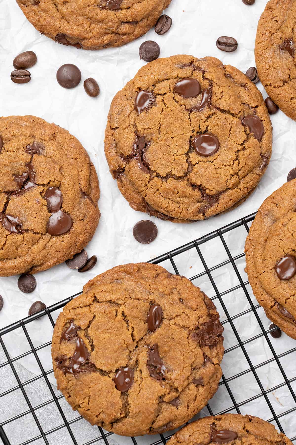 Coffee cookies on baking paper and a cooling rack.