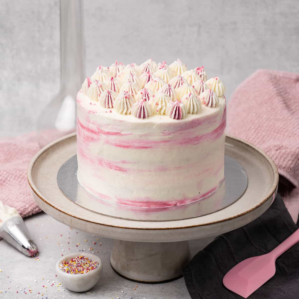 Pink cake on a cake stand.