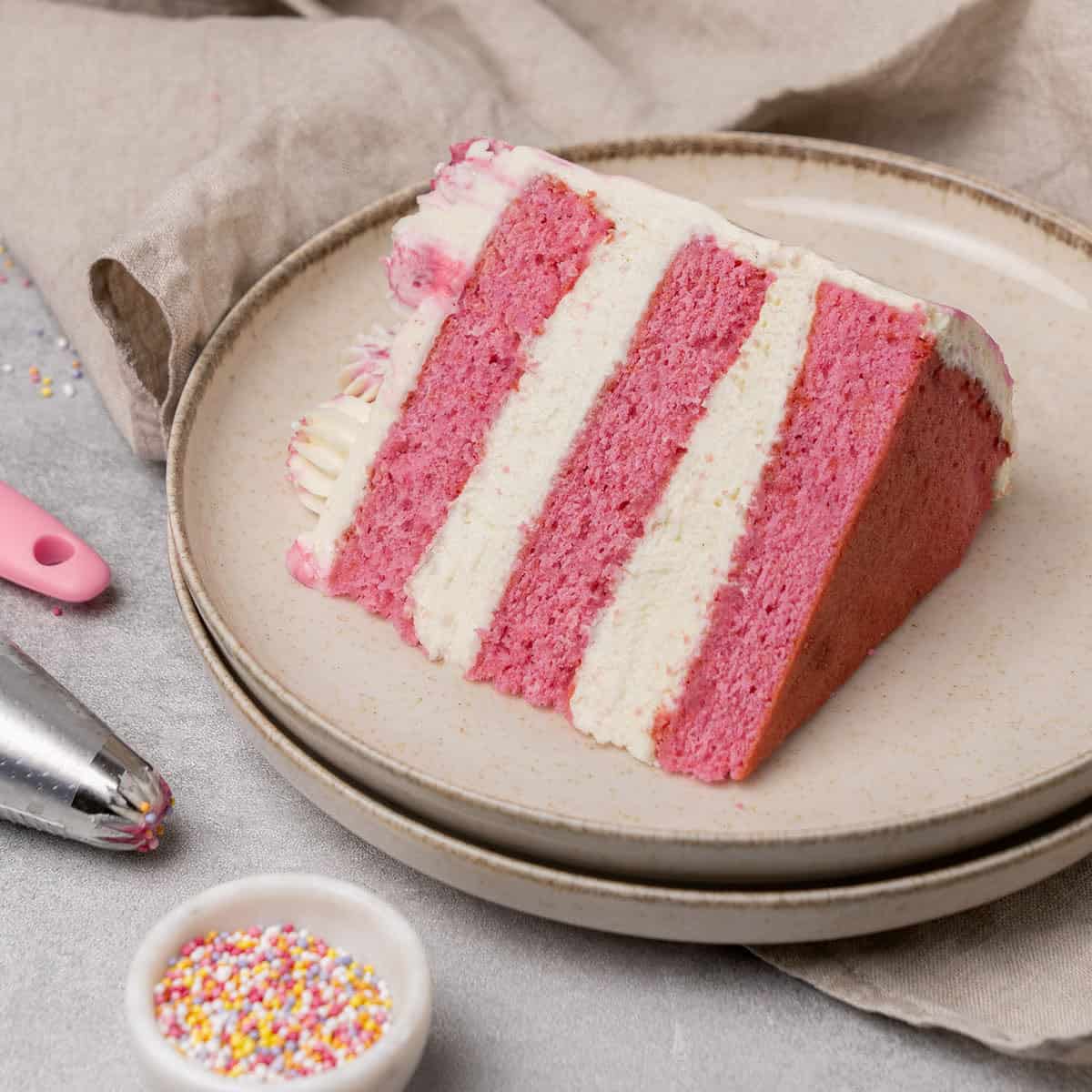 A slice of pink cake on a plate.