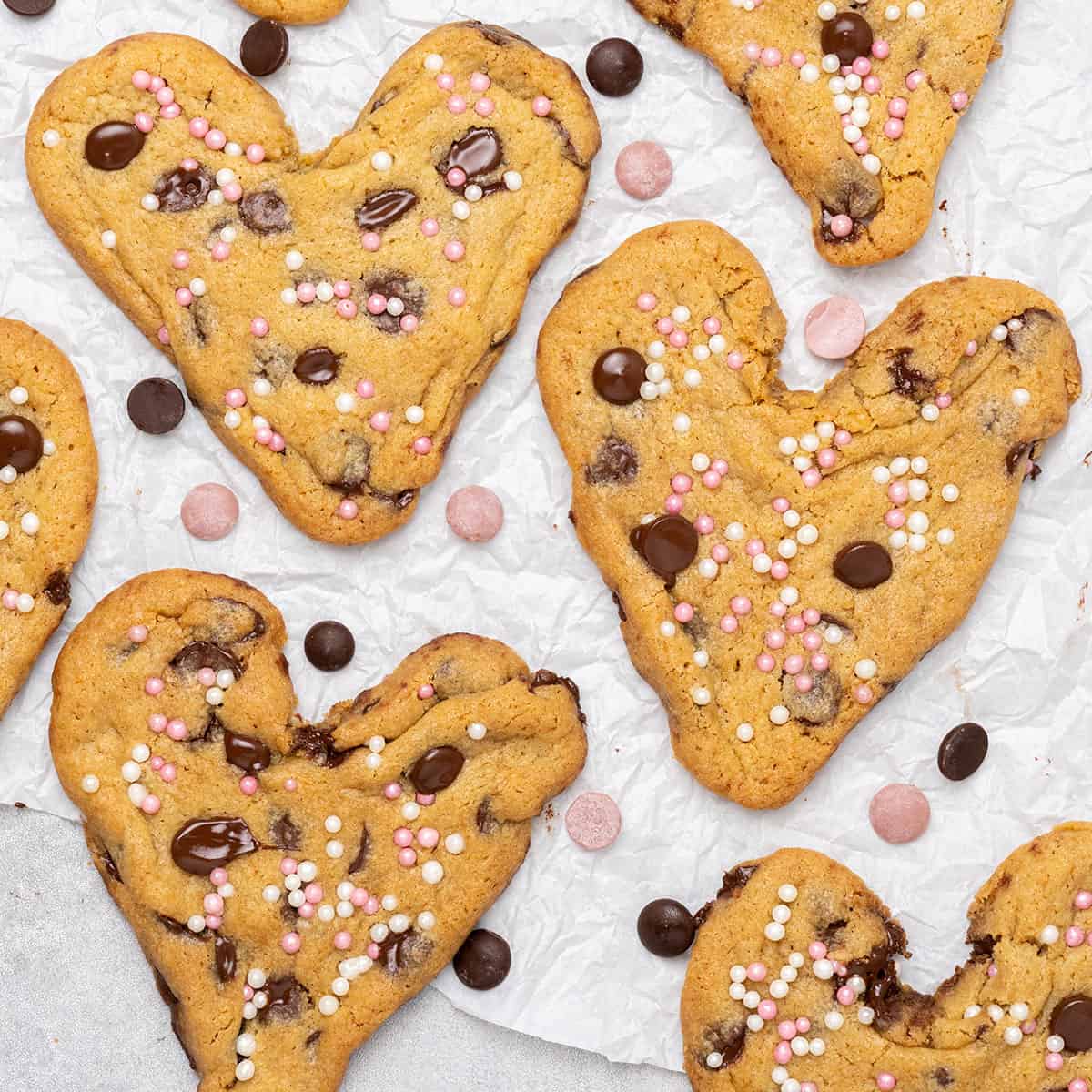 heart-shaped cookies on baking paper and a cooling rack.