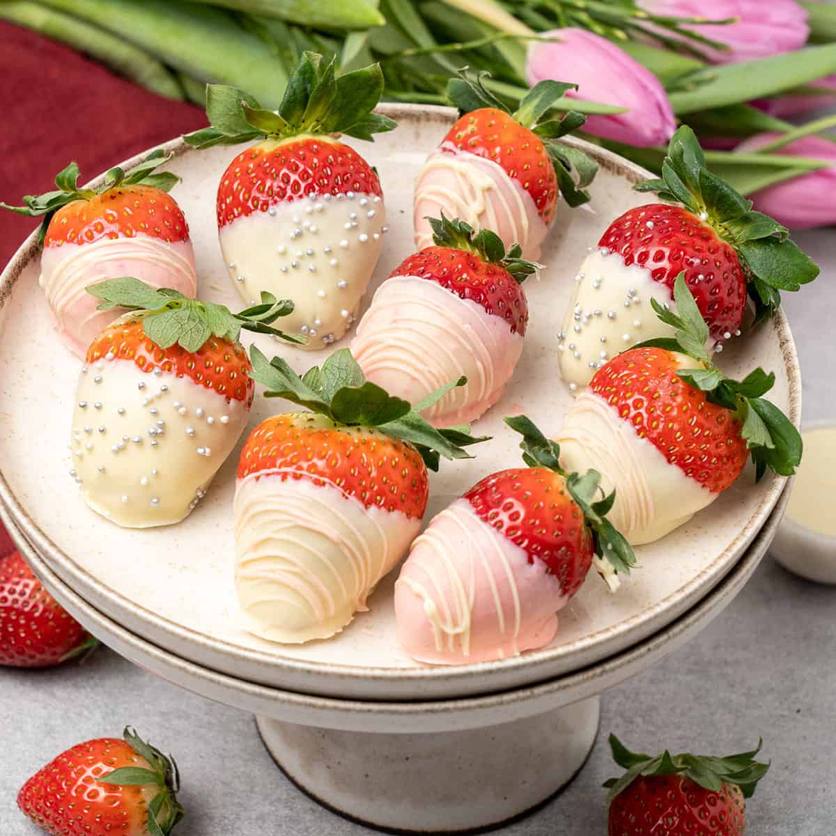 white chocolate covered strawberries on a cake stand.