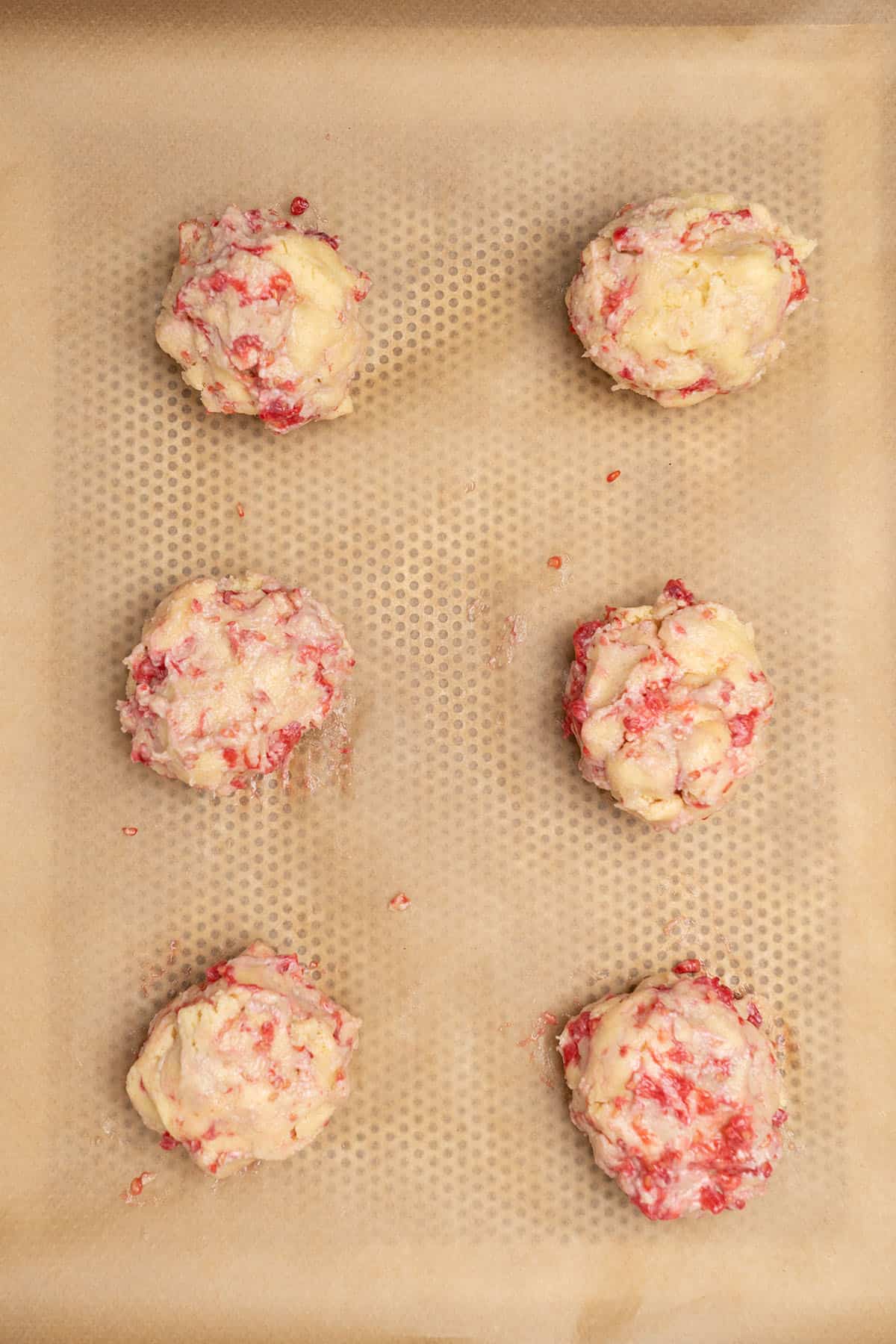 raspberry cheesecake cookies on a baking tray before baking.