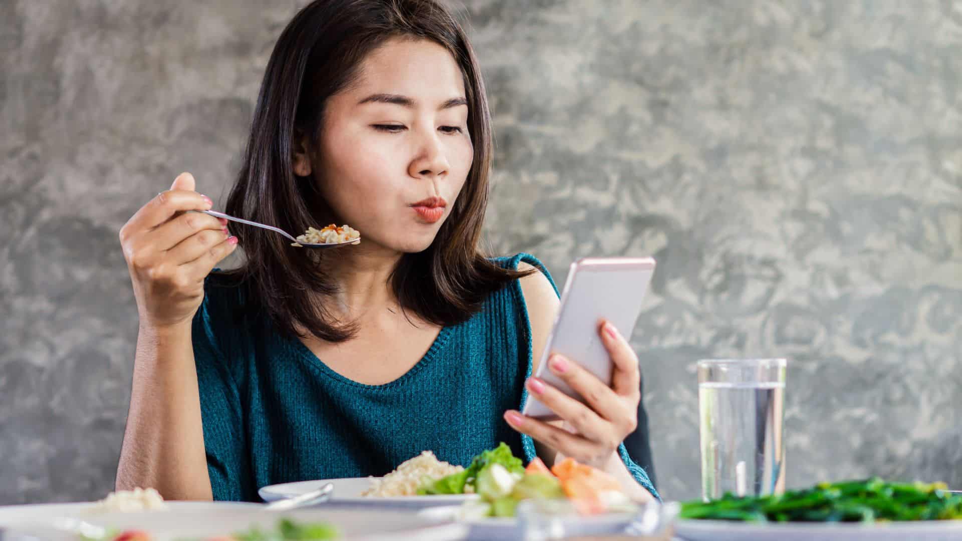 girl with a phone eating.