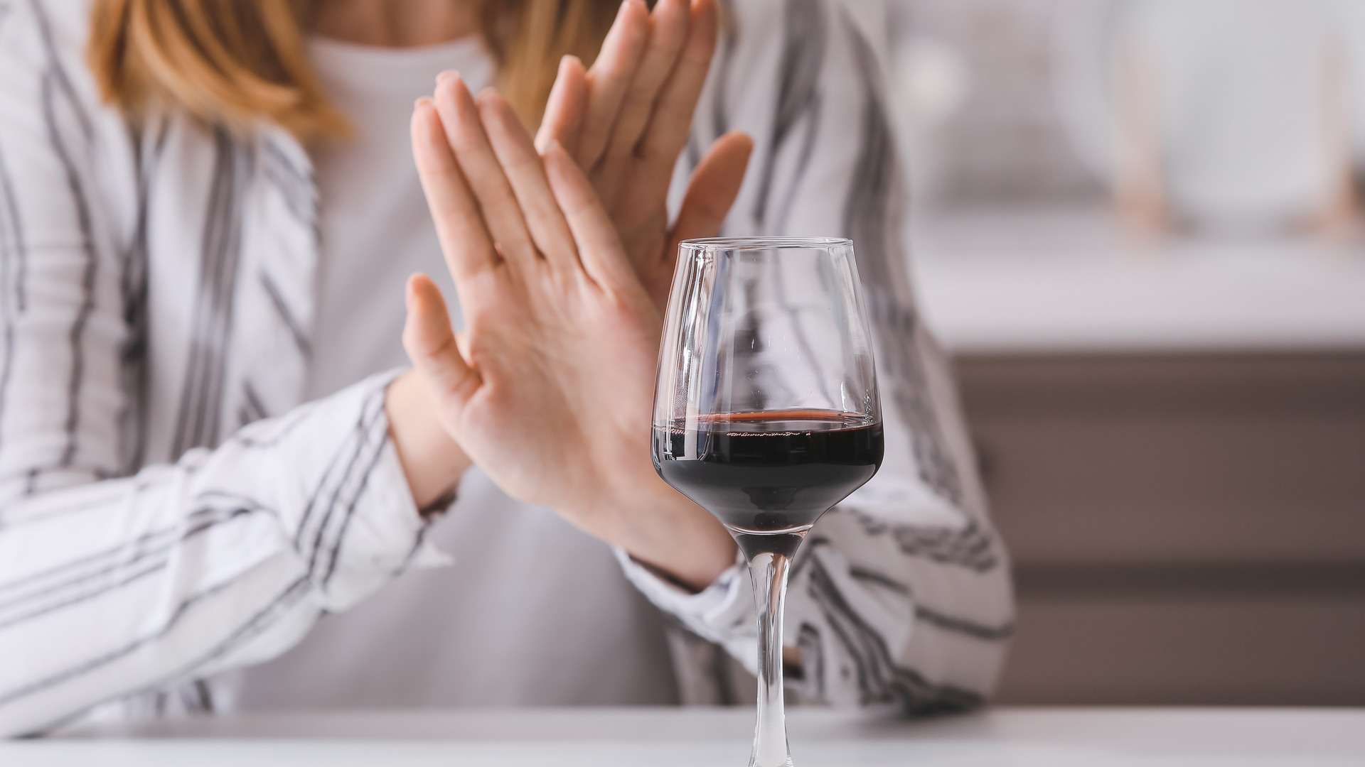 woman saying no to a glass of red wine