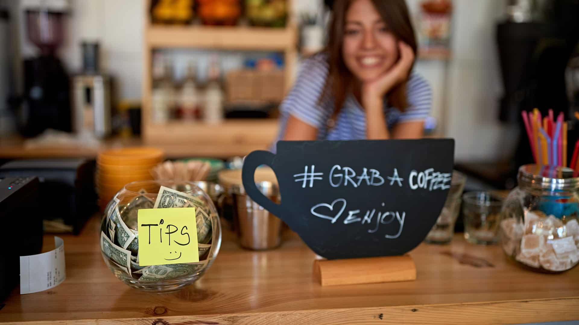 Barista with a tip jar at coffee shop