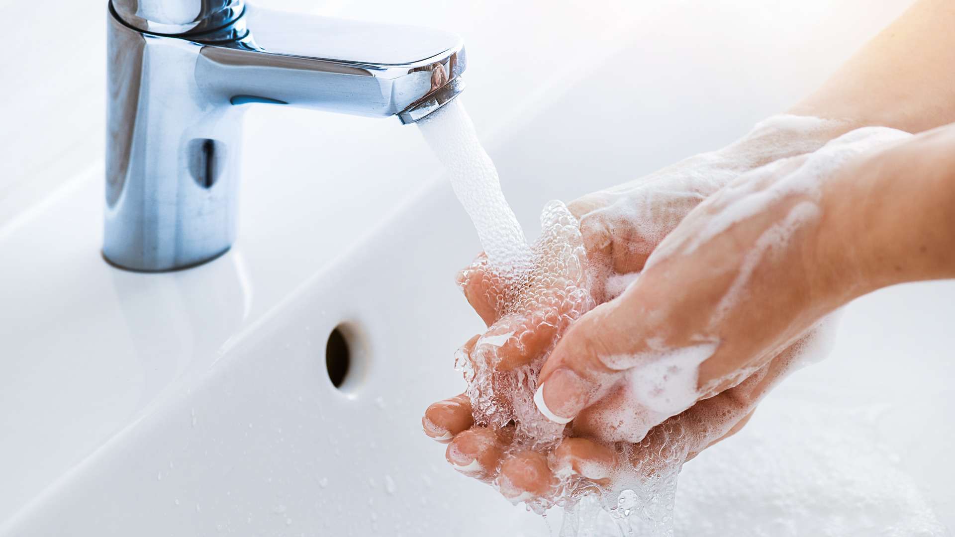 washing hands with soap in sink