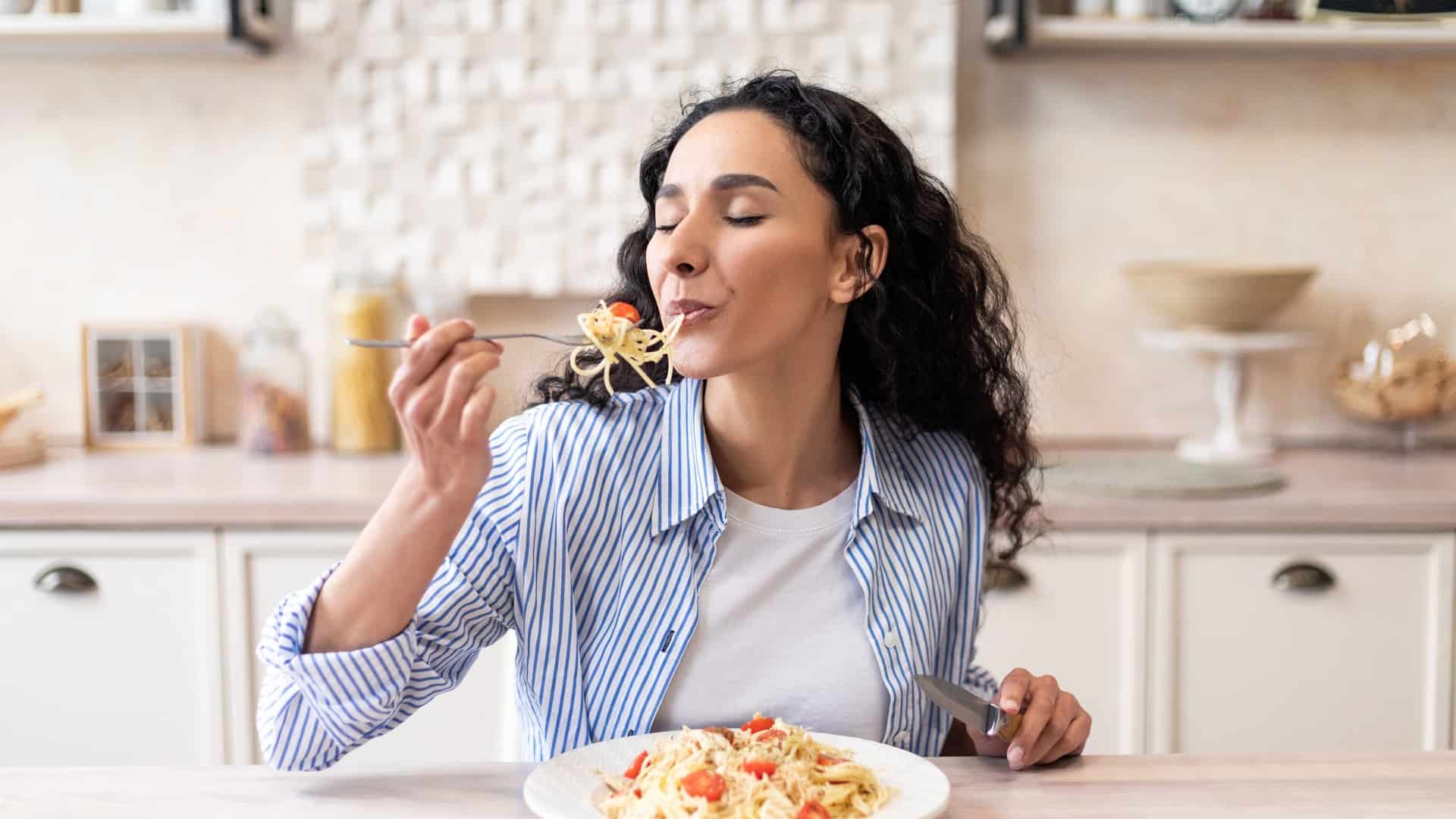 woman eating pasta by herself