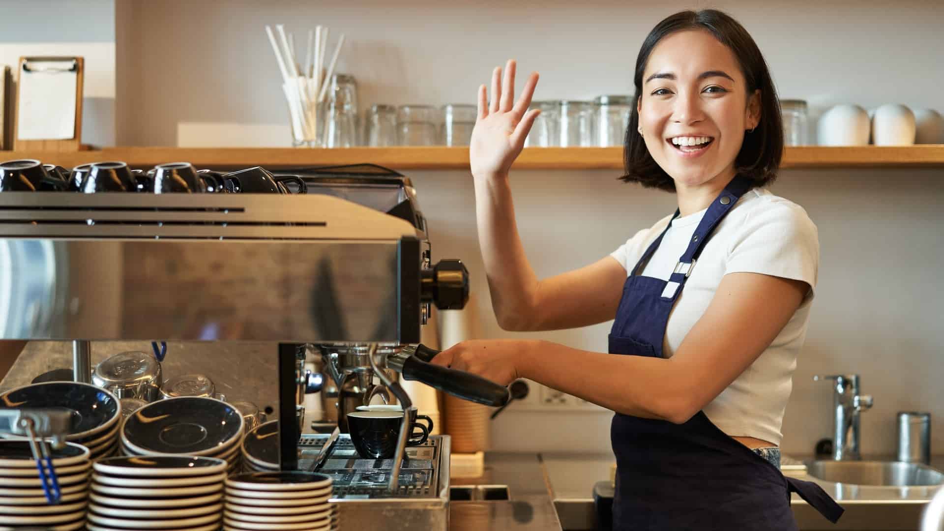 barista waving while making coffee
