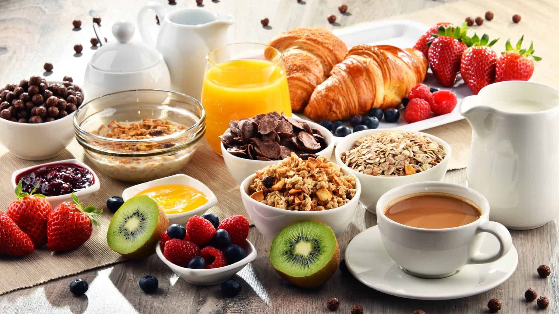 table with breakfast foods, orange juice and coffee