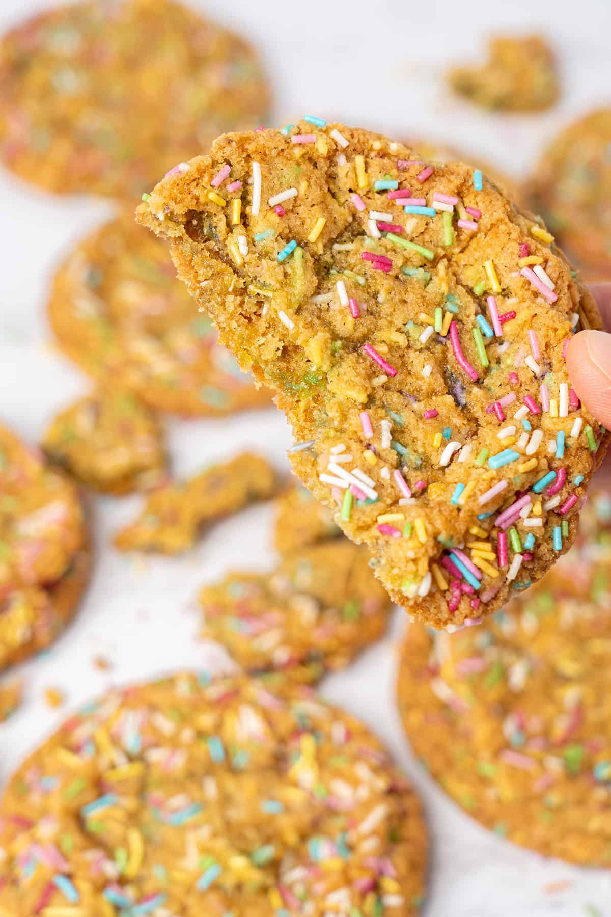 A hand holding a half Funfetti cookie.