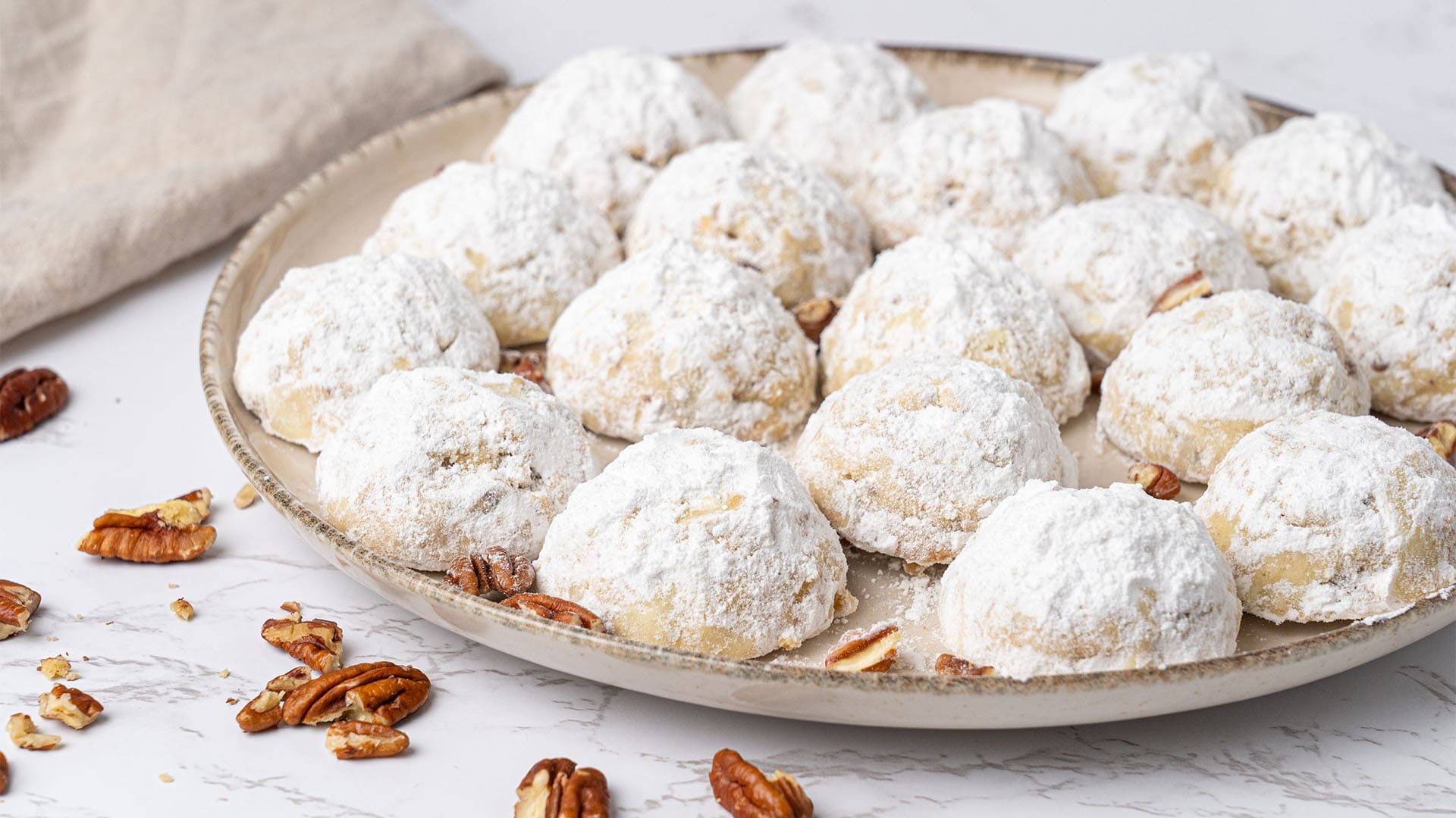 Pecan snowball cookies on a plate.