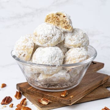 Pecan snowball cookies in a glass bowl.