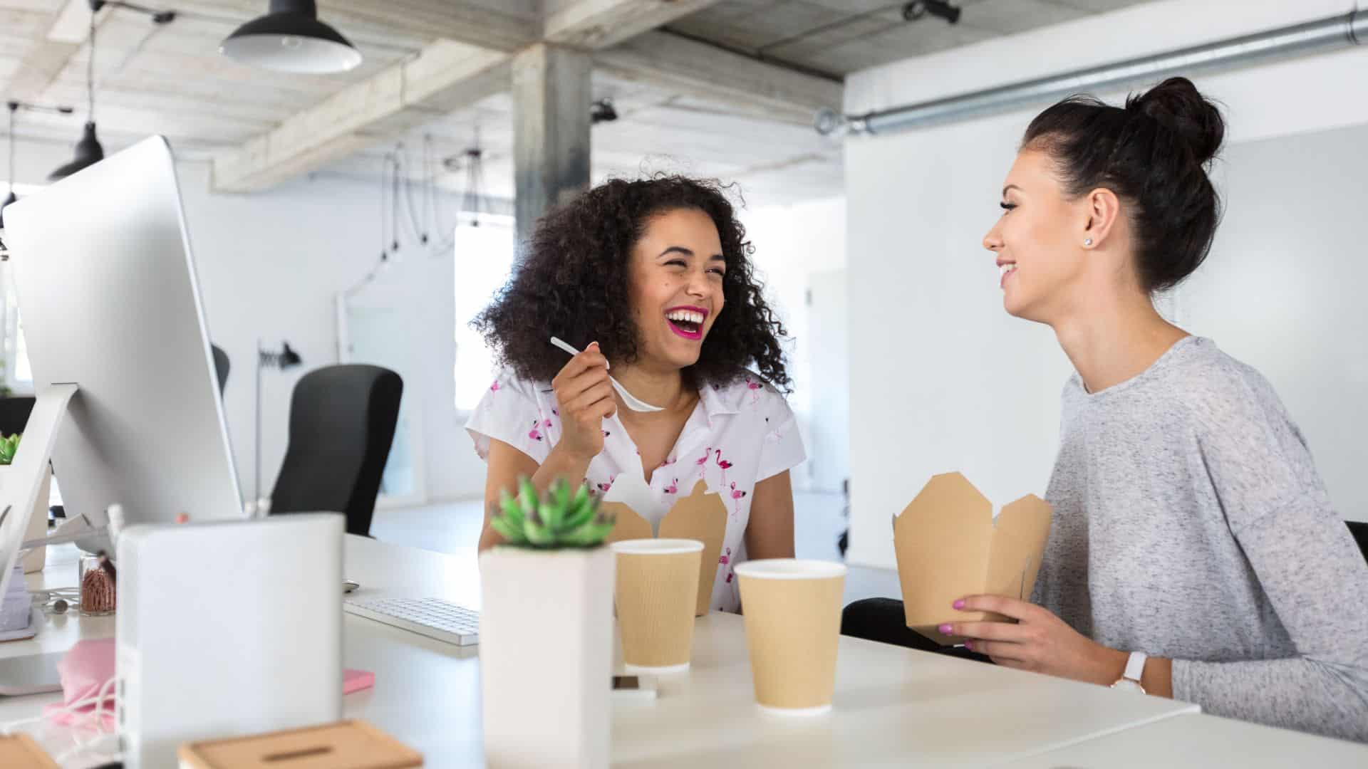 women having lunch at work and laughing