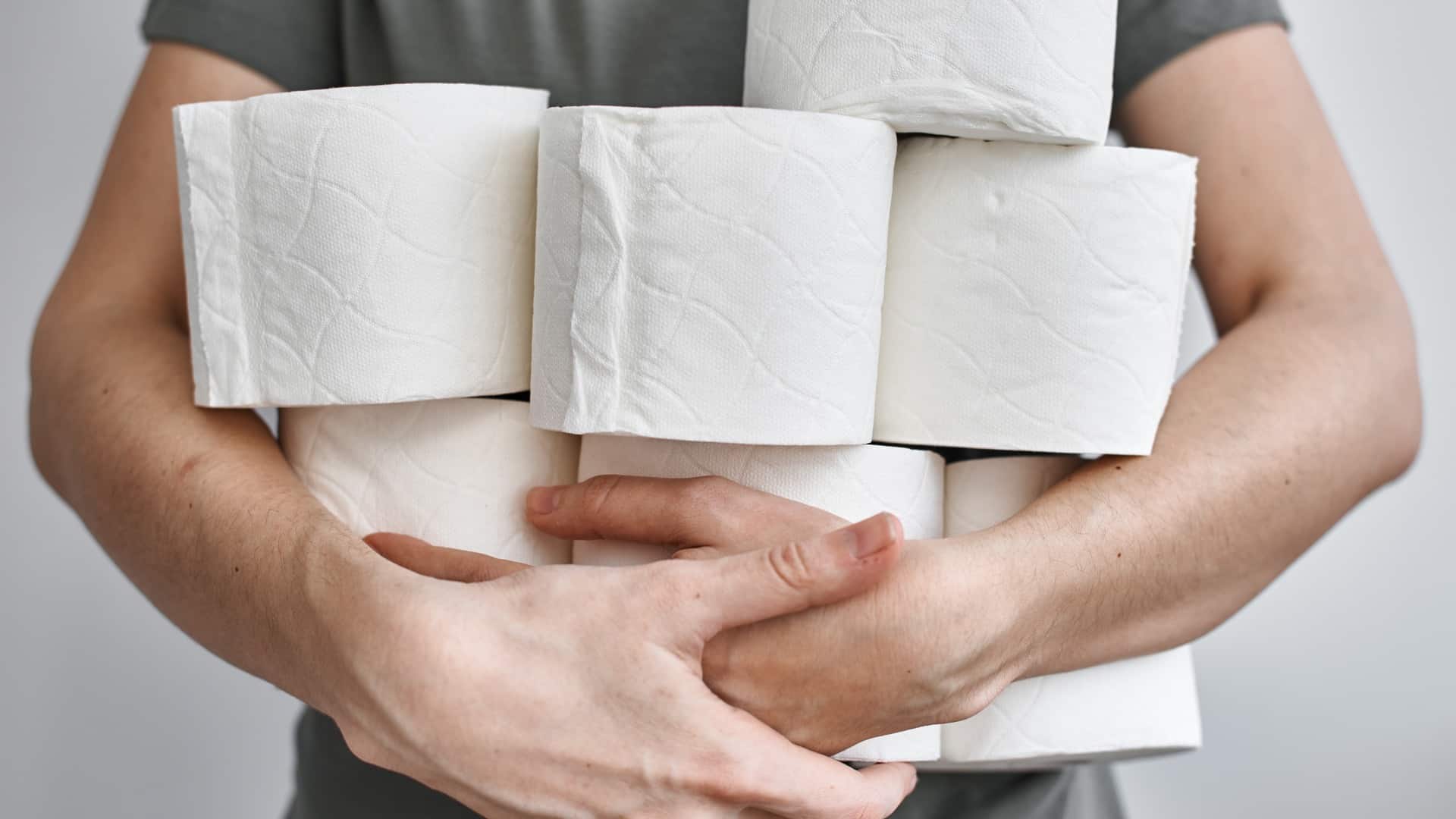 person holding lots of toilet paper