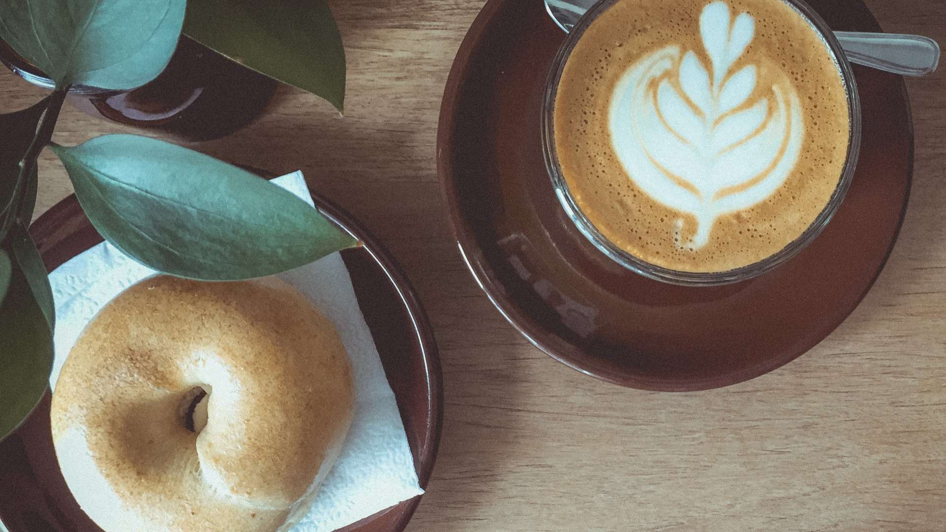 bagel and a latte on a wooden table