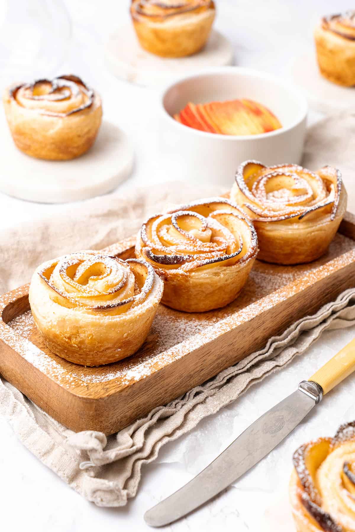 apple roses with puff pastry on a wooden tray.