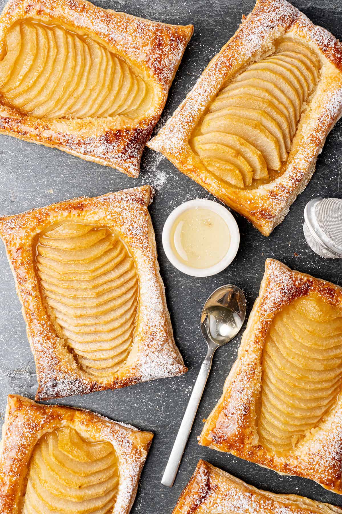 pear puff pastry tarts on a cutting board.